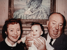 Photograph of Hitchcock holding his first granddaughter, Mary Stone|Mary, in 1953.